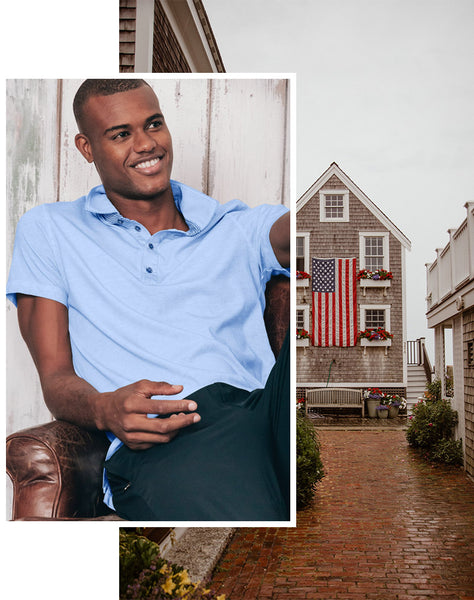 In primo piano un uomo che indossa una polo celeste in jersey. Sullo sfondo una tipica casa vicino all'oceano a Cape Cod, MA