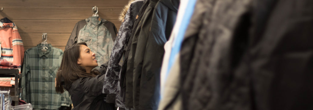 girl shopping, searching through snow jackets