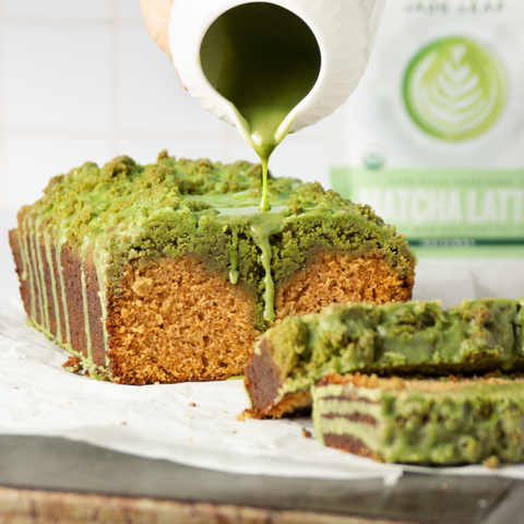 Pouring matcha icing onto a loaf of matcha streusel pumpkin bread