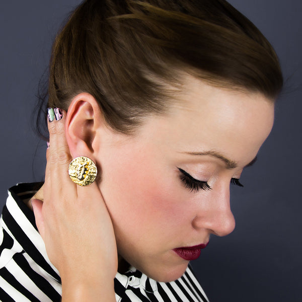 Woman wearing gold stud statement earring
