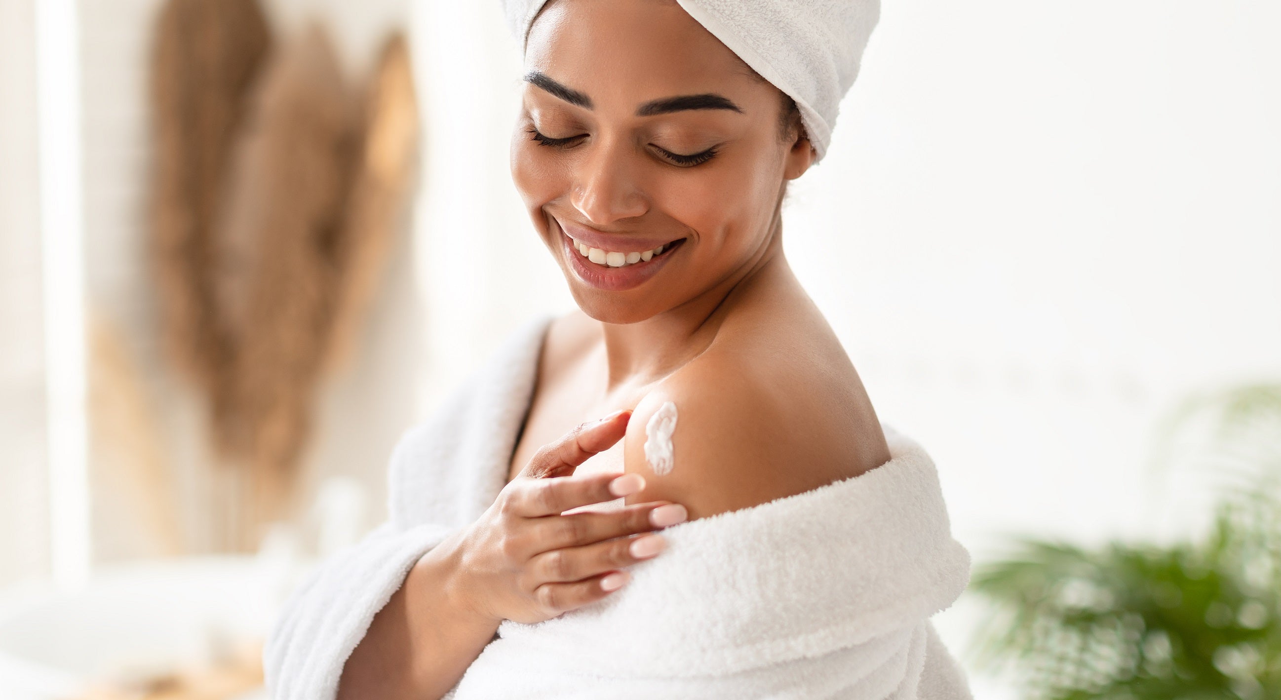 Black woman applying KAIKE Frosting Body Butter to skin after bathing