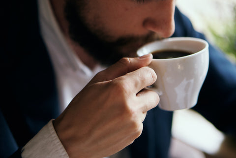 Big coffee cup with man drinking from hose