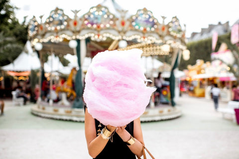 Girl with cotton candy at amusement park