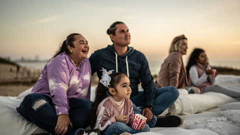 a family watching a movie outdoors