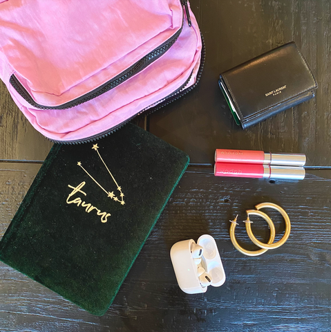 Baggu fanny pack in pink, Apple Airpods Pro, MAdewell chunky large hoop earring, Woosh Beauty's Spin on Lip Gloss, and black YSL wallet