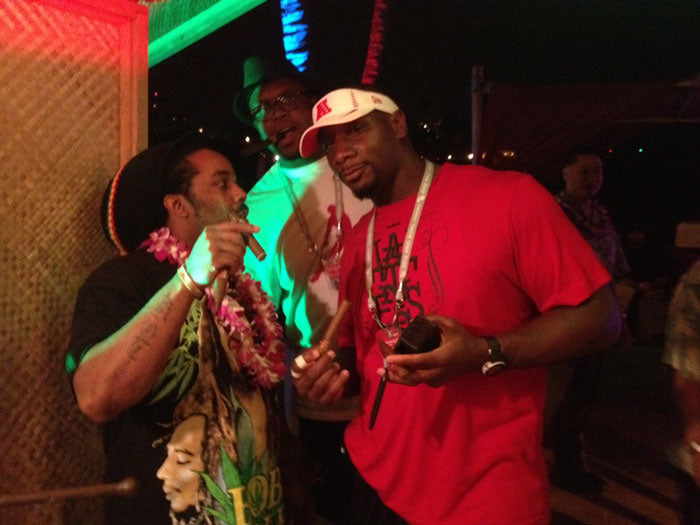 A couple of gentlemen enjoying the cigar rolling demonstration, cigars in hand.