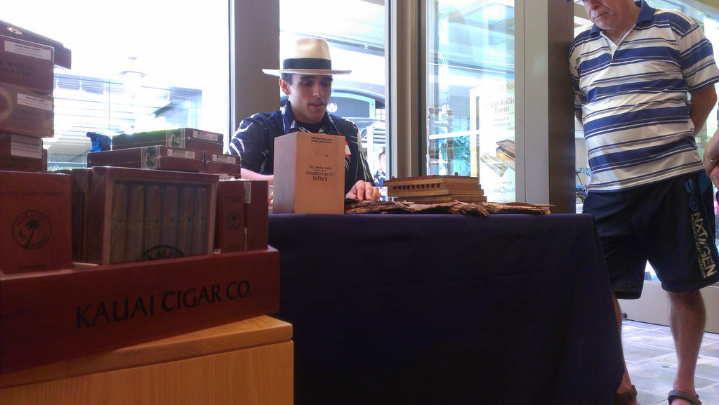 Tai Erum rolling a cigar rolling while explaining the process and answering questions.