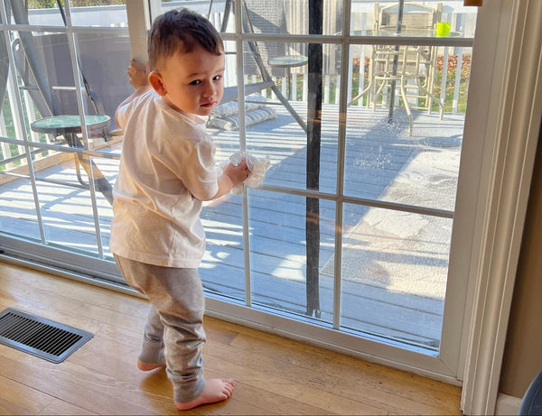 Toddler standing in front of a sliding glass door