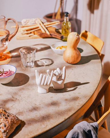 salière et poivrière en forme de mains sur une table 