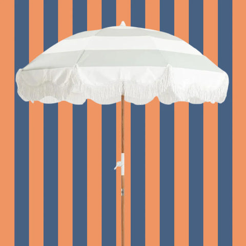 parasol rayé bleu clair et blanc sur fond rayé vertical bleu foncé et orange