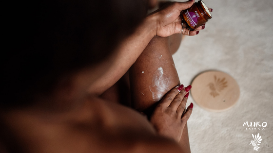 close up shot of massaging body butter into bare legs