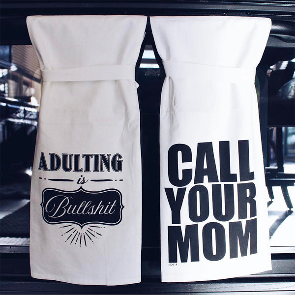 Two flour sack Hang Tight Towels that read: "Adulting Is Bullshit" and "Call Your Mom," respectively.
