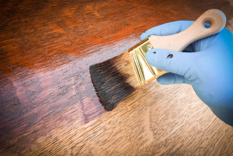 man refinishes furniture