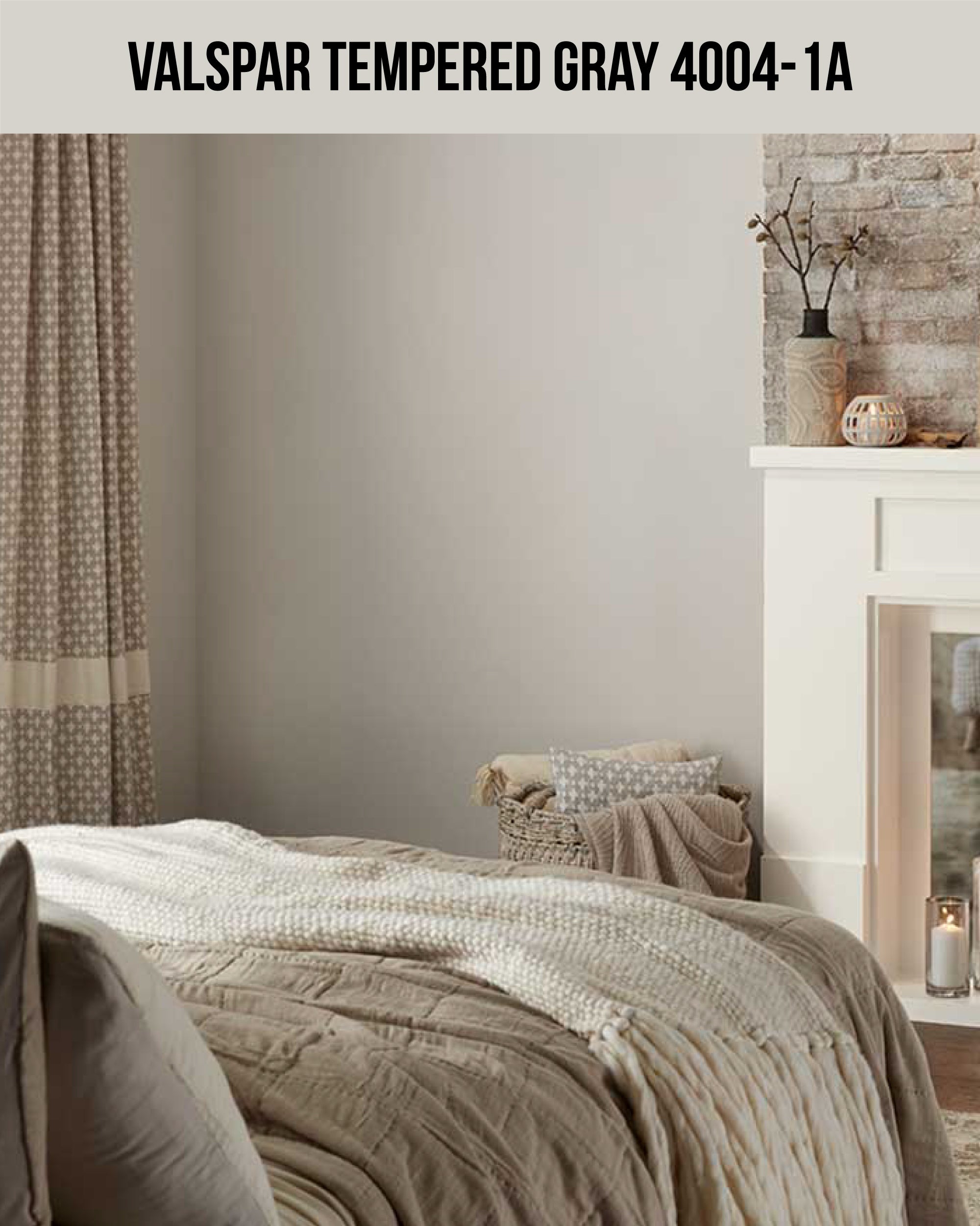 A bed with a blanket and candles in a fireplace with a gray paint color wall (Valspar Tempered Gray 4004-1A)