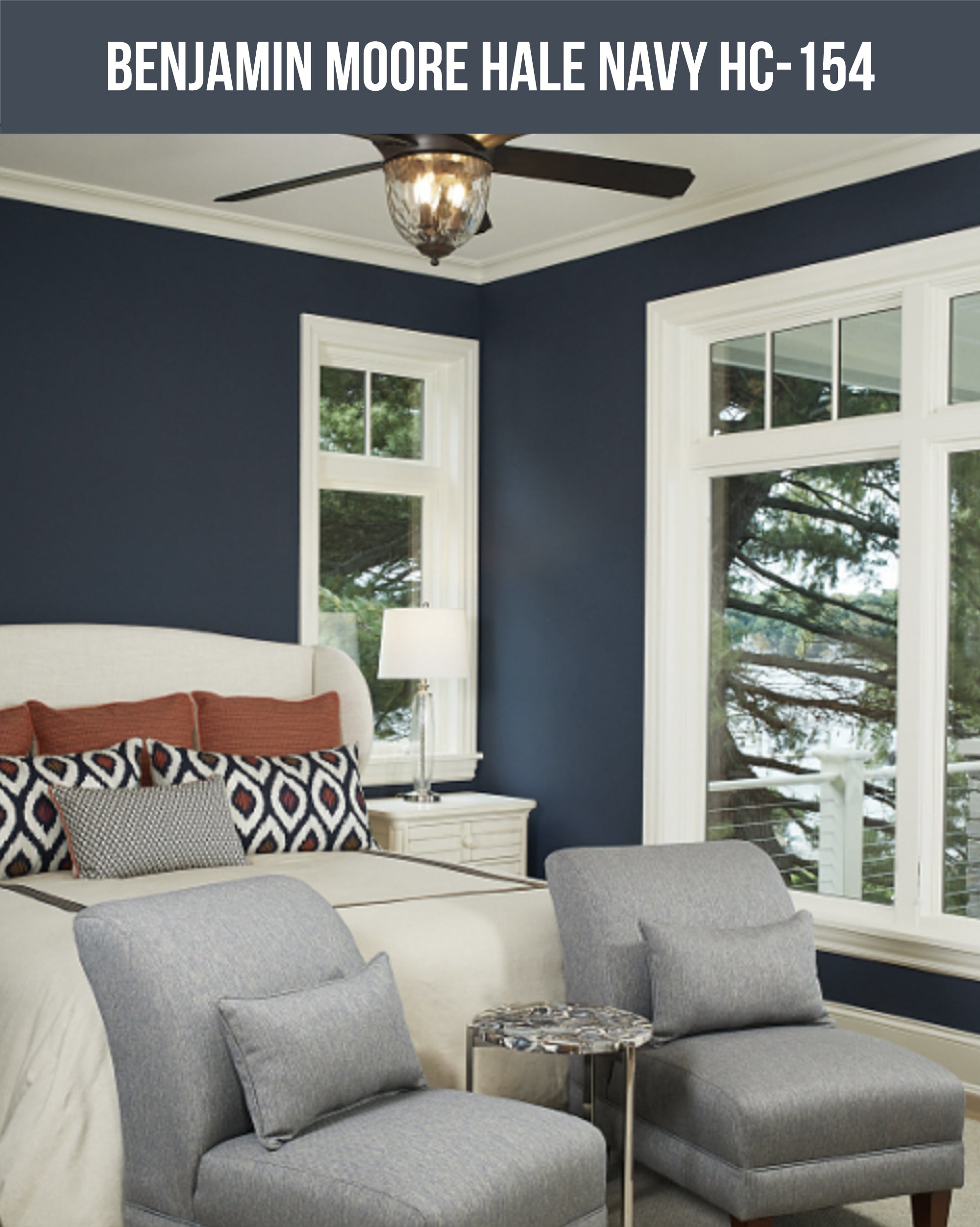 A blue painted bedroom with a bed and chairs (Benjamin Moore Hale Navy HC-154)