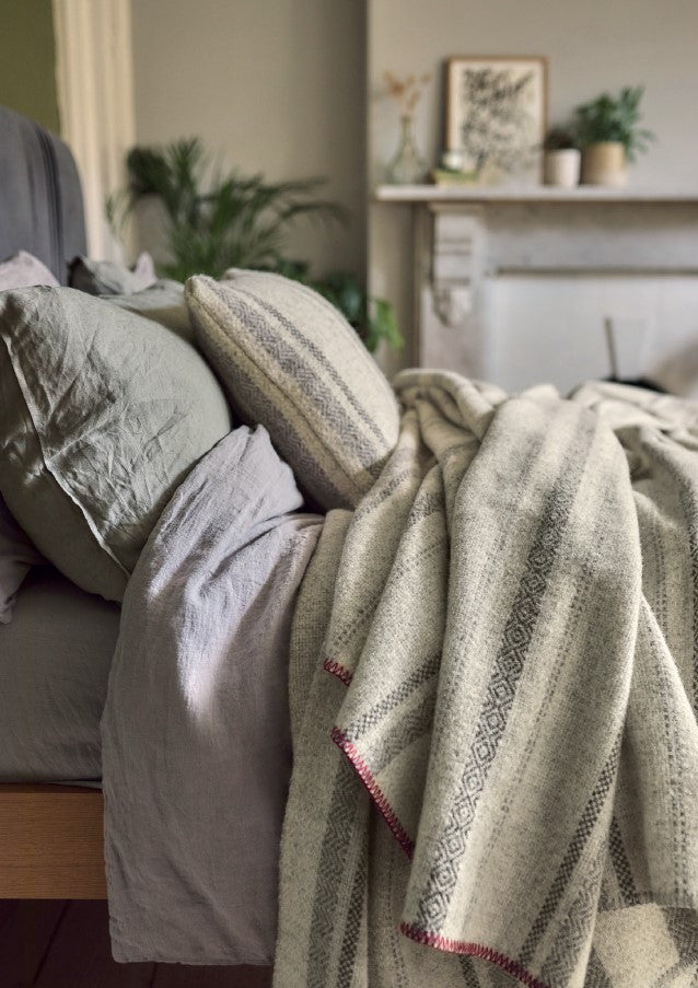 bed with 100 percent british wool throws blankets cushions by The British Blanket Company