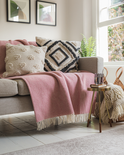 Dusky Pink Signature Herringbone Throw from The British Blanket Company arranged on a neutral sofa