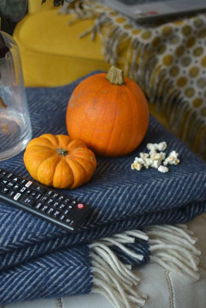 cosy living room movie night with wool blankets and popcorn on a yellow sofa