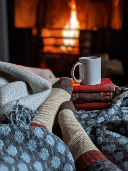 cosy scene with wool blanket by and open fire