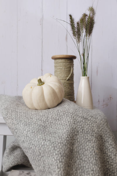 neutral halloween decor with blanket and pumpkin