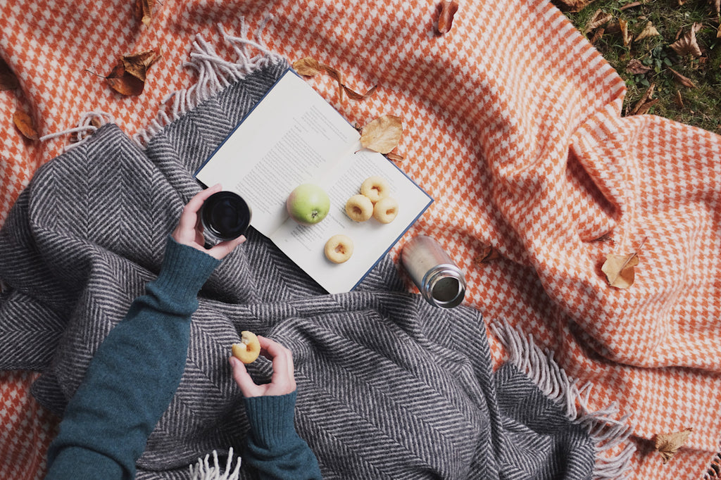  The British Blanket Company autumn picnic with orange and grey wool blankets coffee flask and miniature donuts