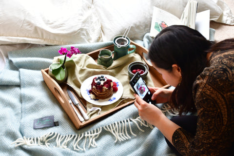 intern at The British Blanket Company takes a picture of a breakfast tray on a blanket