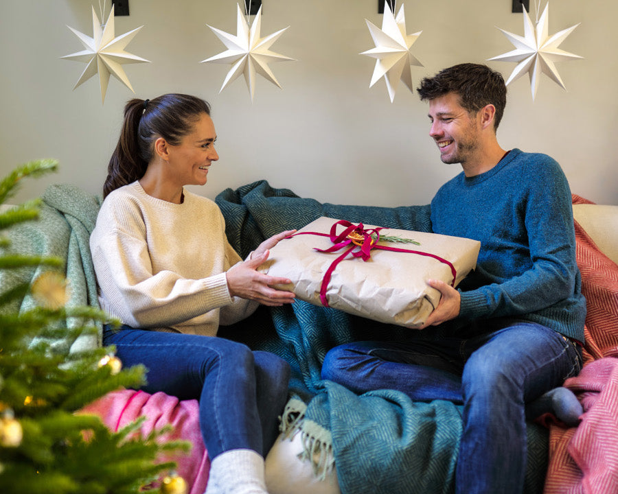 smiling couple exchanging main Christmas present - gift ideas for Christmas The British Blanket Company