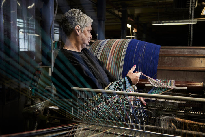 woman at a UK weaving mill makes recycled wool throw blankets for The British Blanket Company