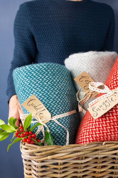 Basket with wool blankets and Christmas luggage labels