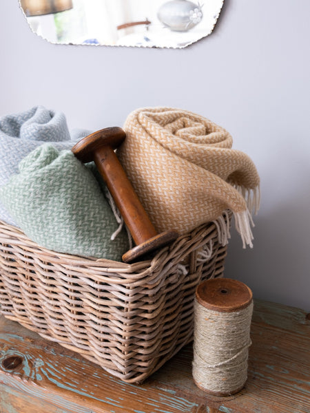 wool blankets from The British Blanket Company rolled in a wicker basket
