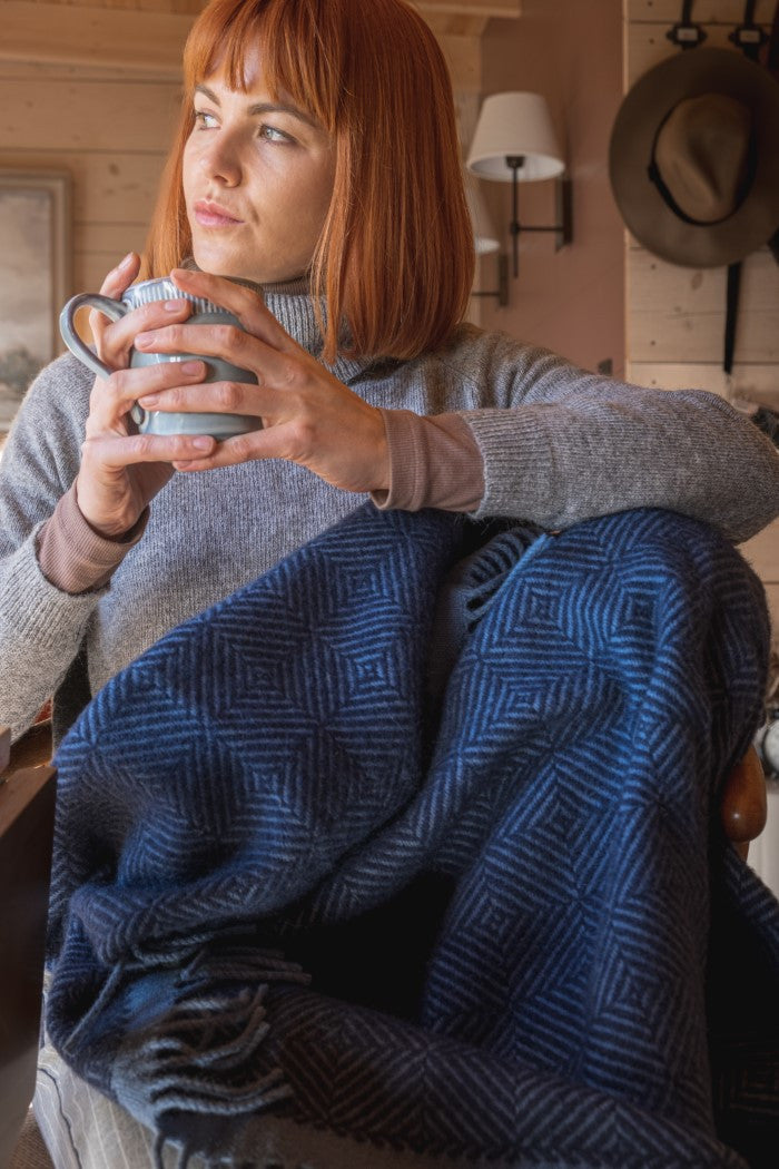 The British Blanket Company blue wool blanket from natural wildweave collection and woman drinking tea