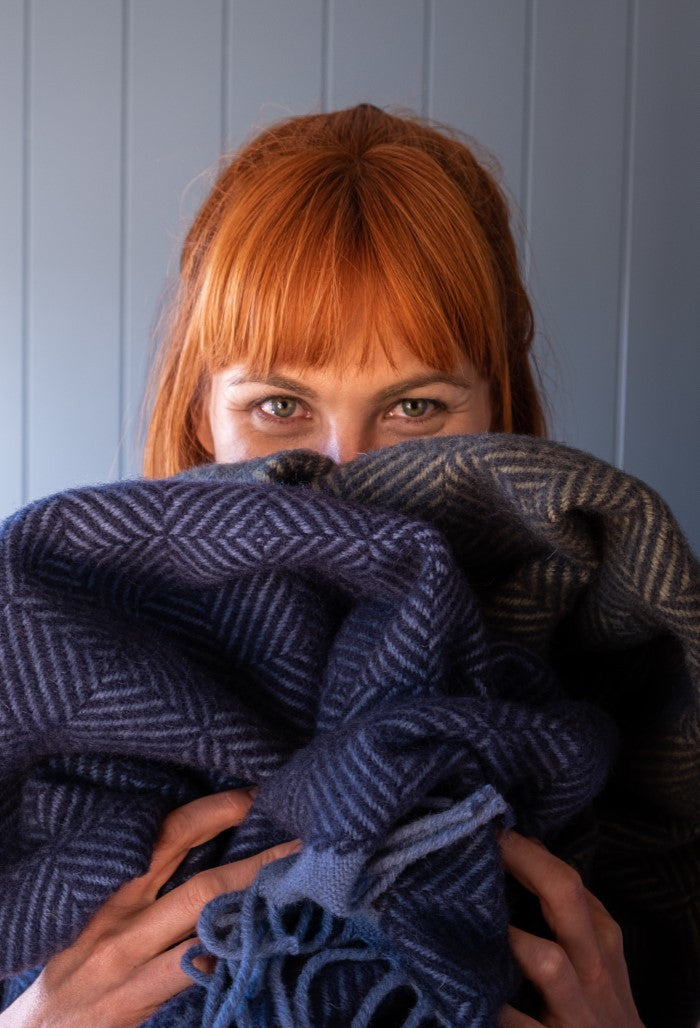 The British Blanket Company woman holding blankets from the natural wool wildweave collection