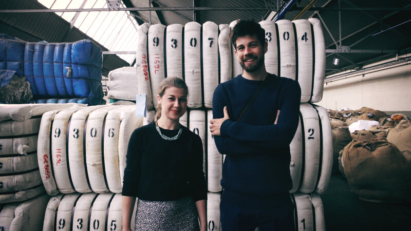 Bethan John and Joe John co-founders of The British Blanket Company stand in front of bales of wool