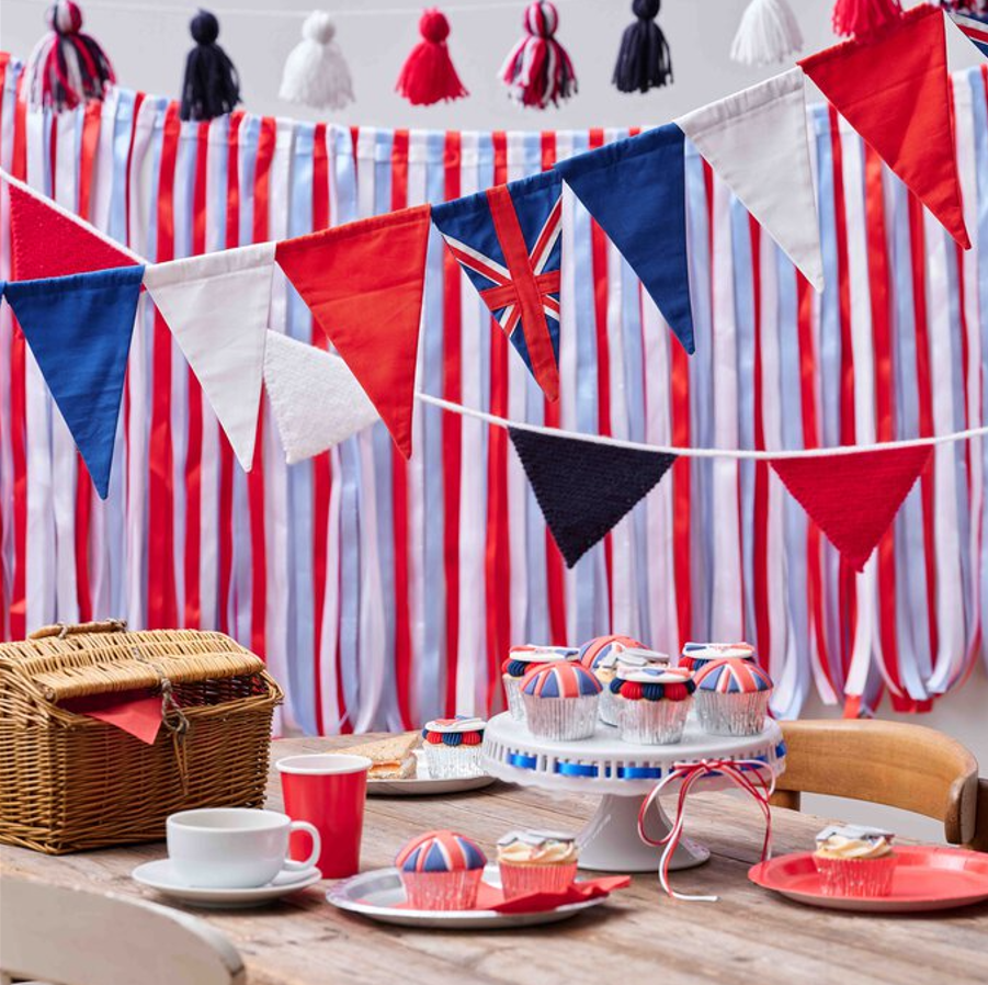 queens jubilee picnic decorations in red white and blue with handmade bunting and party food on a table