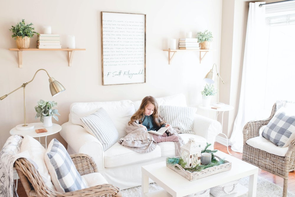 girl sits in light bright coastal decor living room