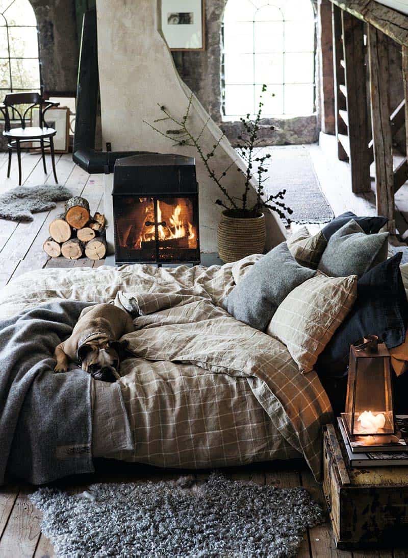 bedroom with woodburning stove and cosy bedding and blankets