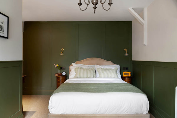 olive green bedroom with a wool blanket on the bed