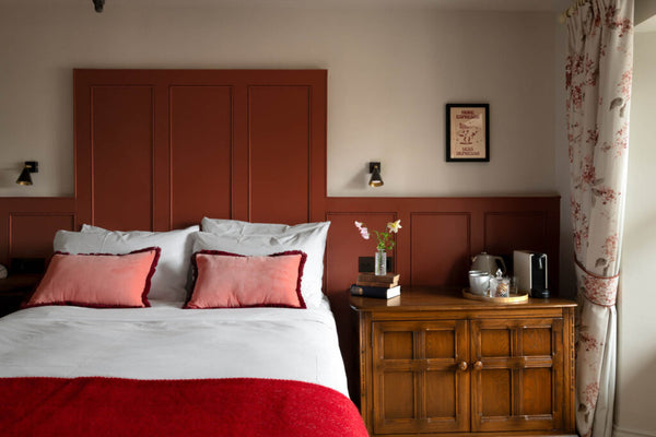 bedroom with red painted panelling and wool blanket