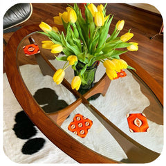 customer photo of Inkabilly 70s Op Art Coasters on a Gplan glass top table with a vase of tulips and a cowhide rug
