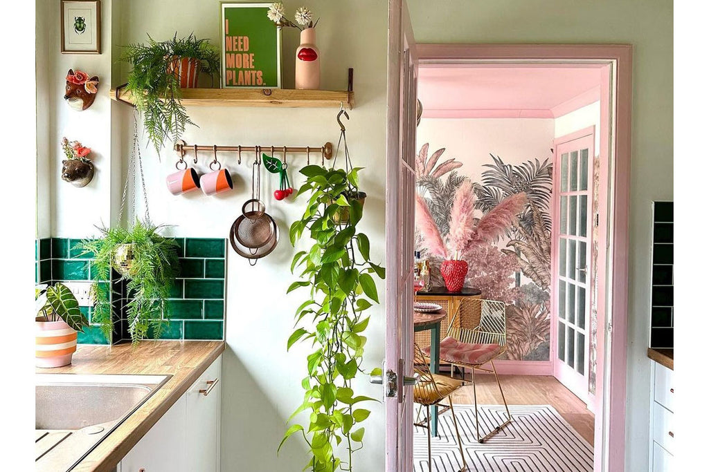 View from a kitchen through to a pink dining room with patterned wallpaper. Image credit : Rachel Verney @the_shoestring_home