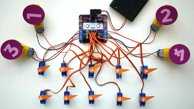 Looping video of a small purple circuit board with a smiling face on it connected to 14 motors all of which are moving back and fourth