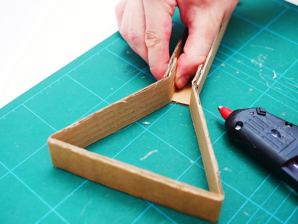 Image shows back frame being stuck to central crane feature by holding pieces together, since glue pattern has been applied.