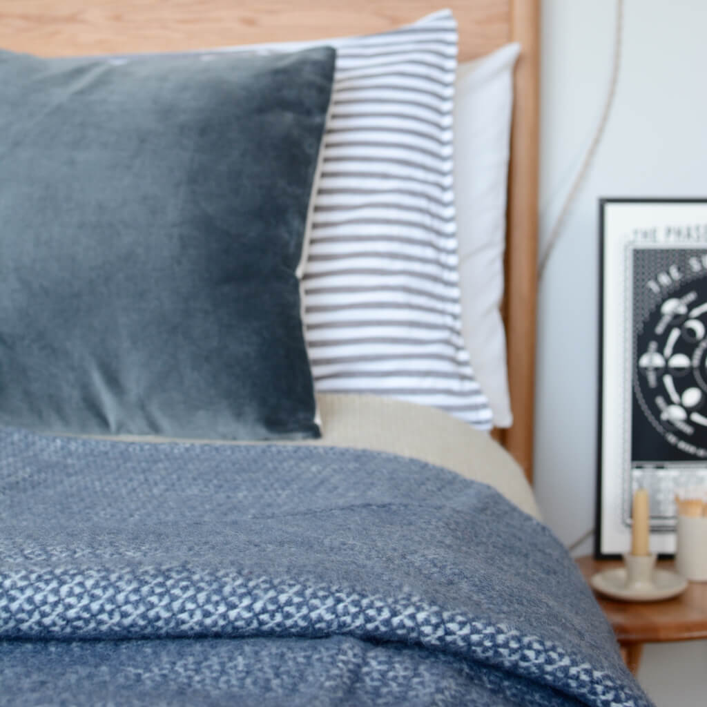 A blue windmill design blanket on a bed