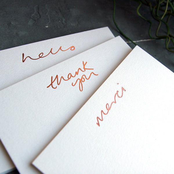 group shot of notecards that say hello, thank you and merci