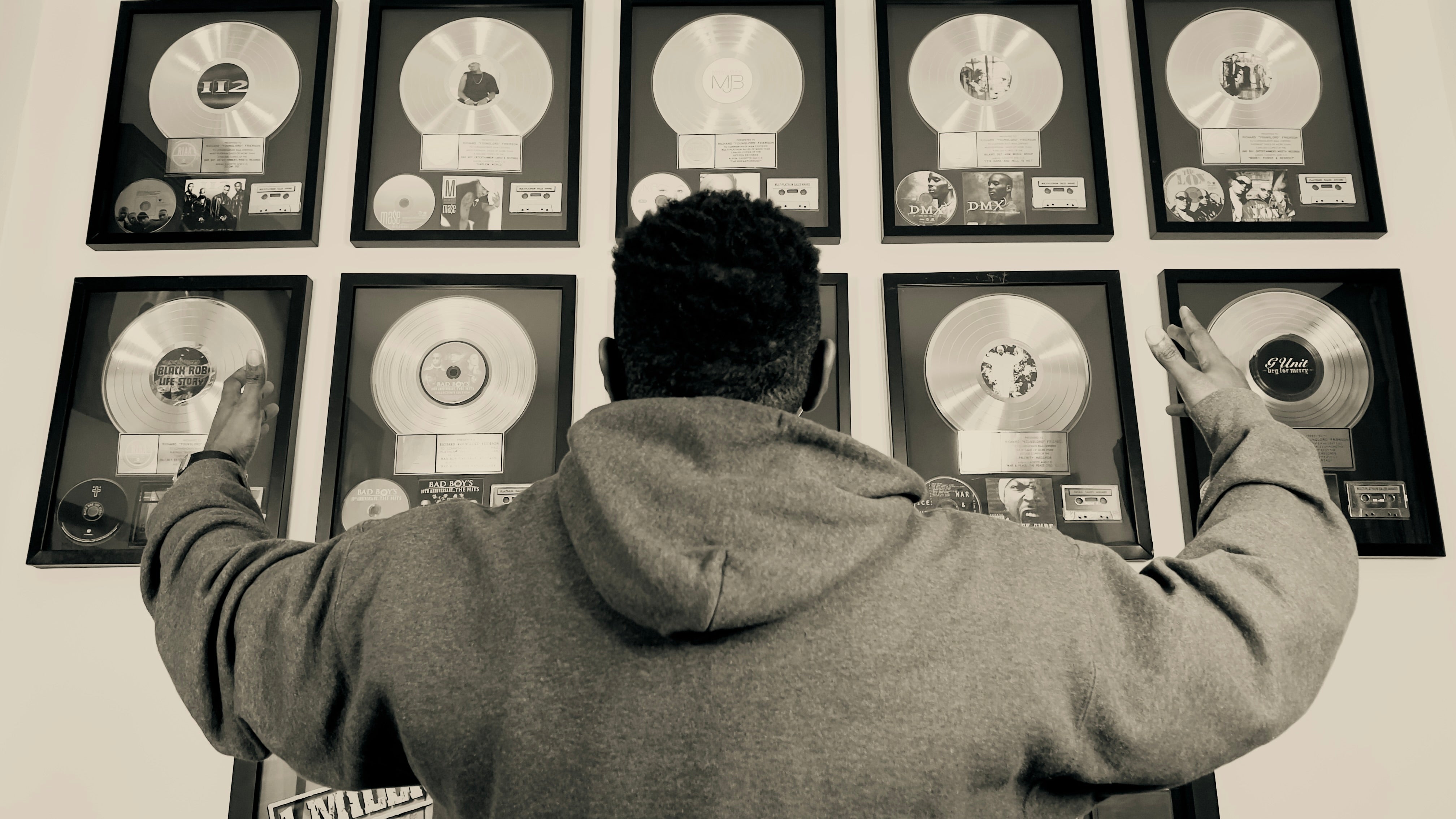 Image of music producer in front of plaques 