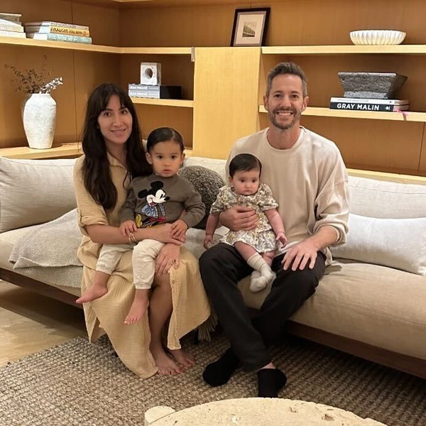 two adults and two small children sitting on a couch