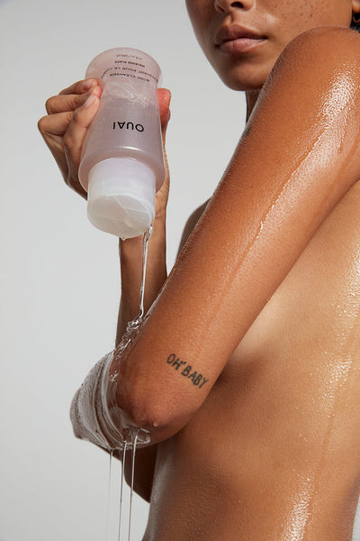 Model pouring out OUAI Body Cleanser on arm