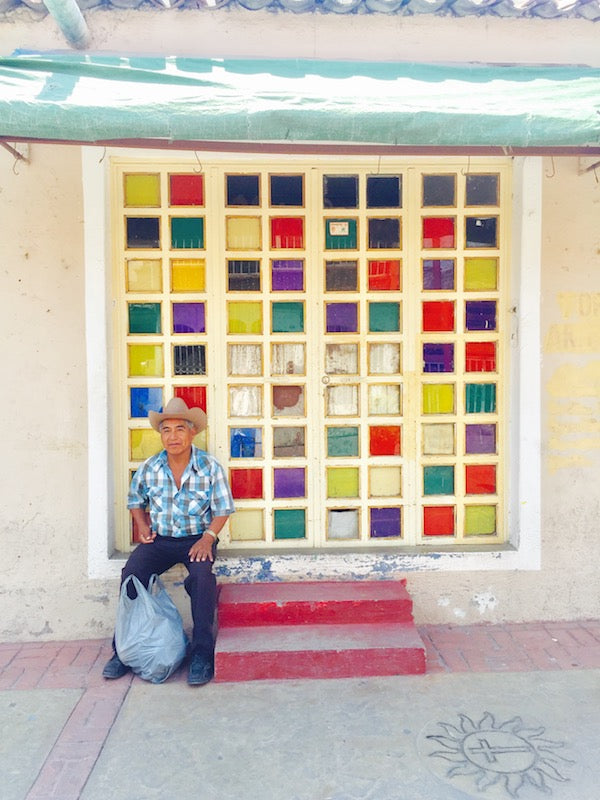 Man resting in front of glass tile wall in Tlaquepaque, Guadalajara, Mexico