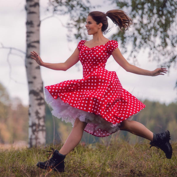 Malli hypähtelee metsässä punainen mekko yllään