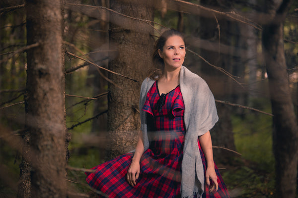 Nainen metsässä ruudullisessa mekossa huivi hartioilla